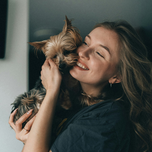 A-lady-hugging-her-small-puppy A lady hugging her small puppy.